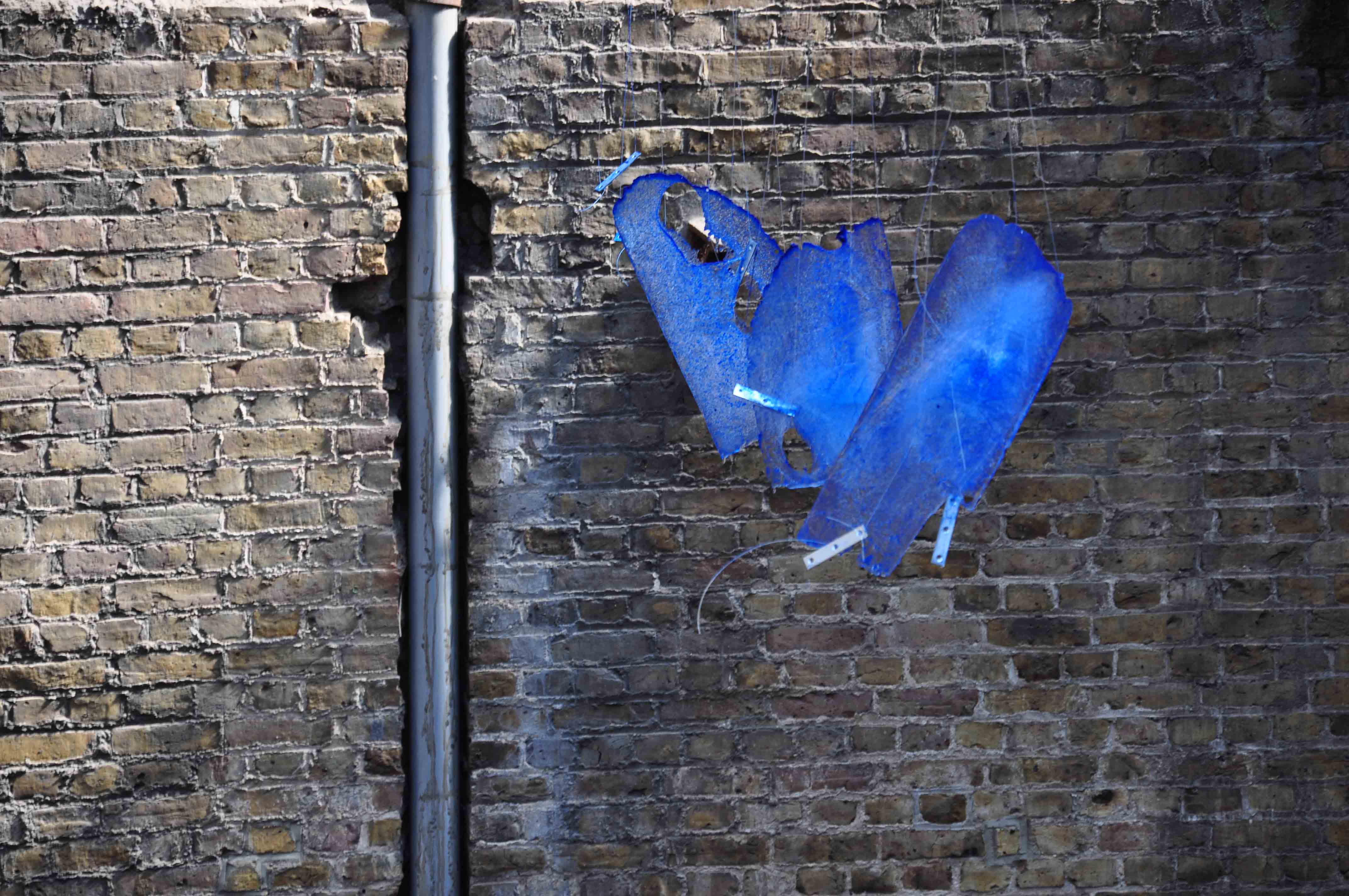 Diffraction — suspended pigmented ice against brick